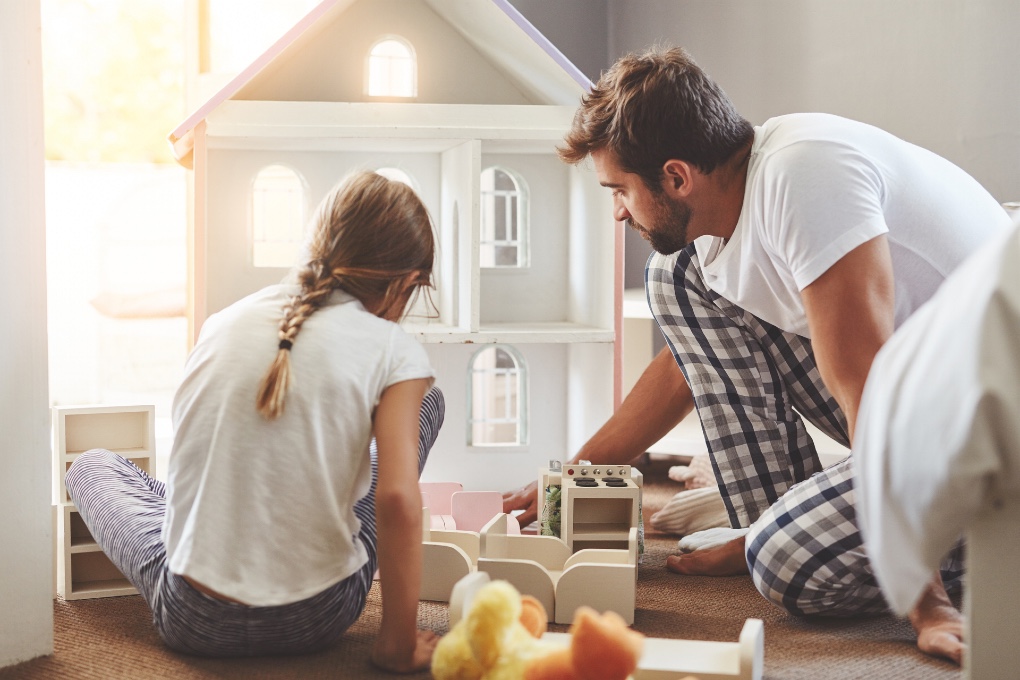 Photo of dad and daughter playing with a dollhouse